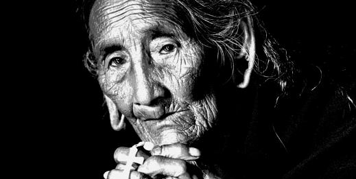 Portrait of elder woman looking into camera, black and white close-up